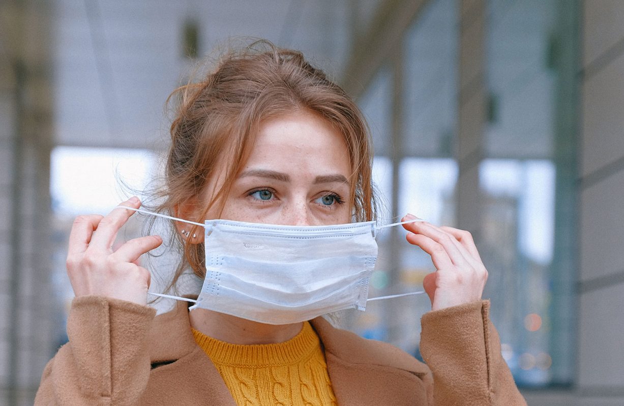 Photo of woman putting on mask